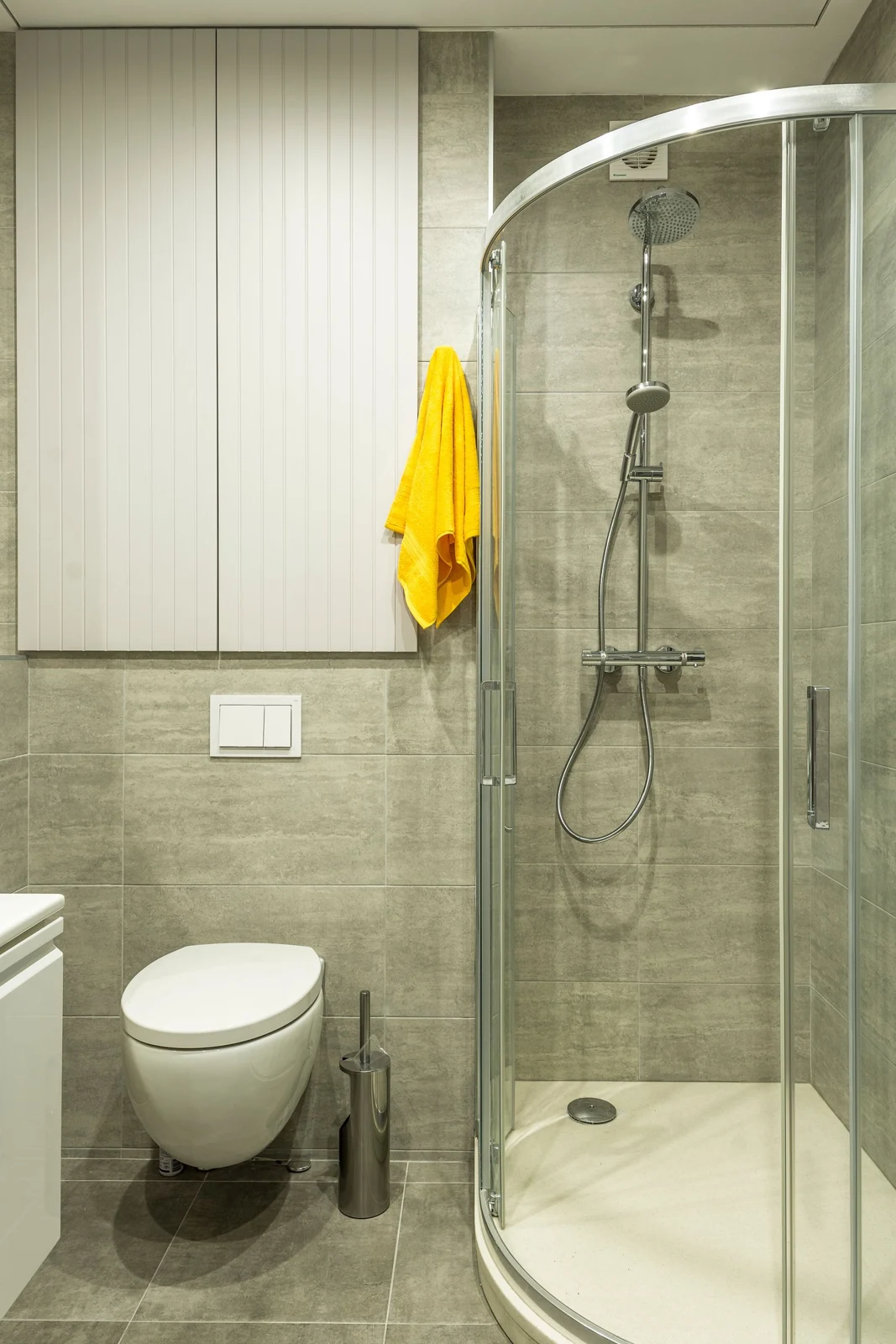 Sliding shower enclosure beside a toilet
